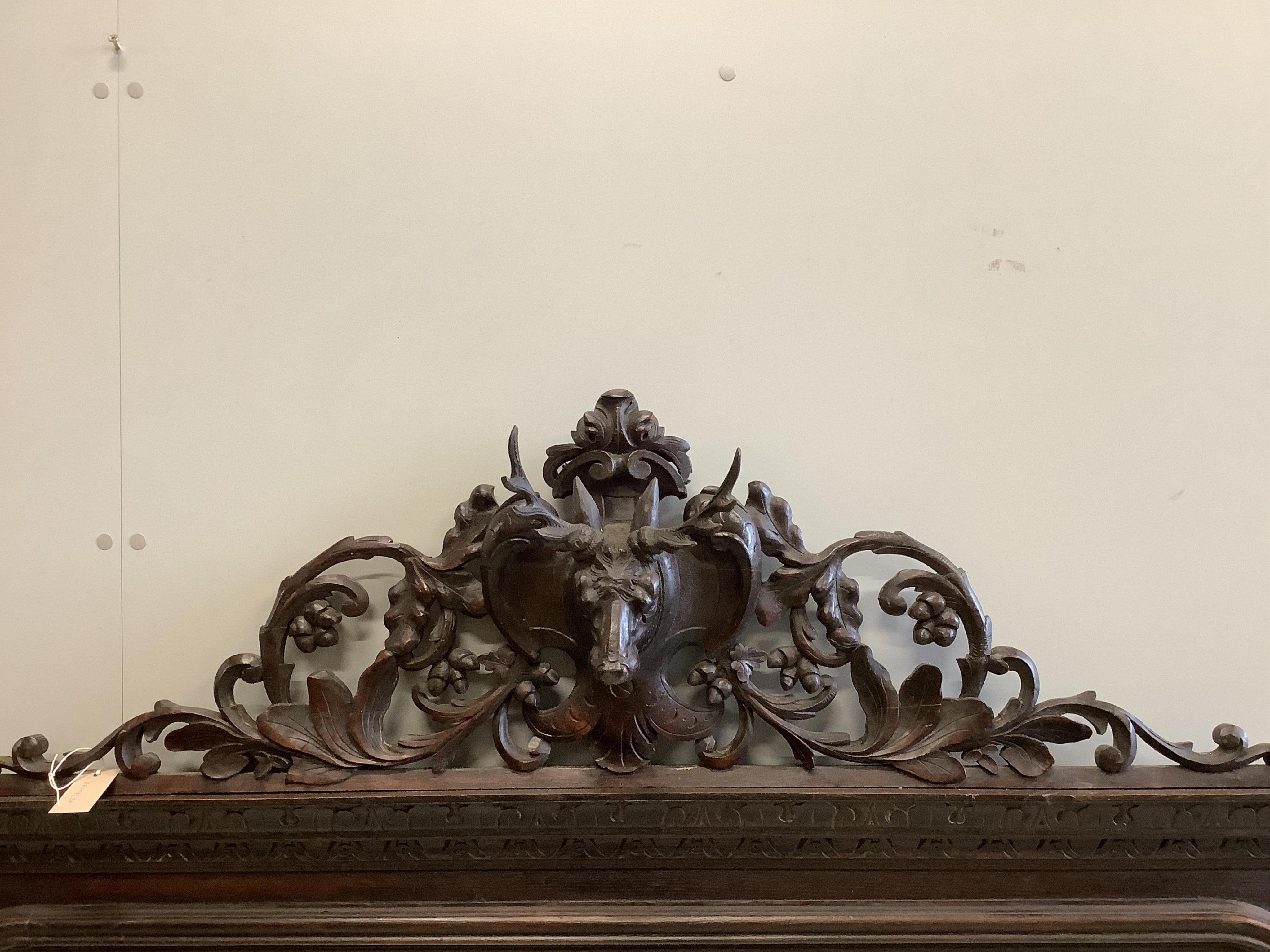 A Victorian oak overmantel mirror with carved stag's head pediment, width 163cm, height 146cm. Condition - fair